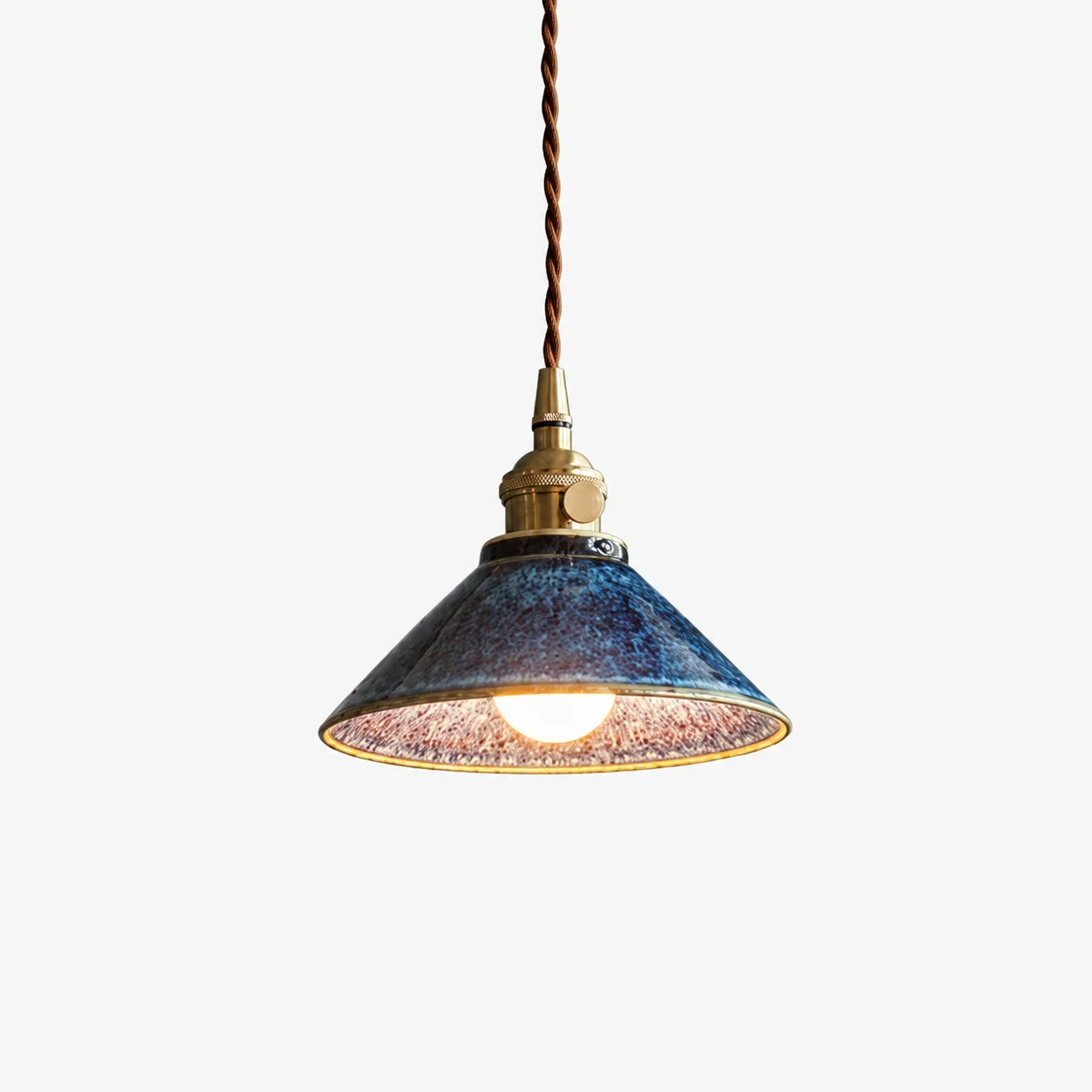 Tenmoku blue glazed ceramic pendant light on white background