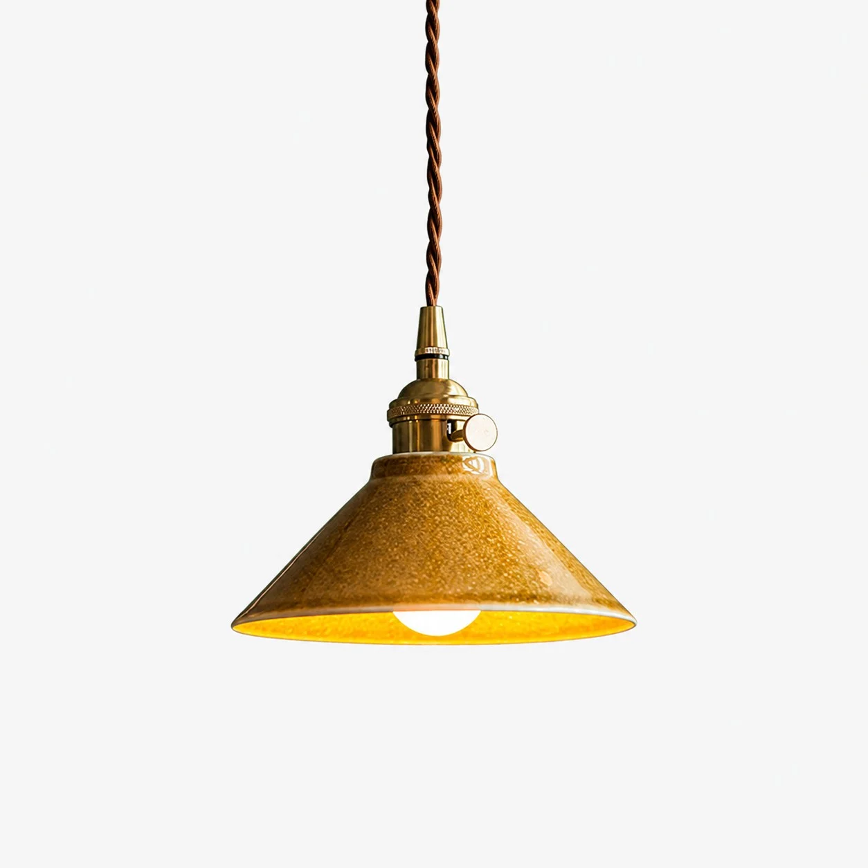 Yellow glazed ceramic pendant light on white background