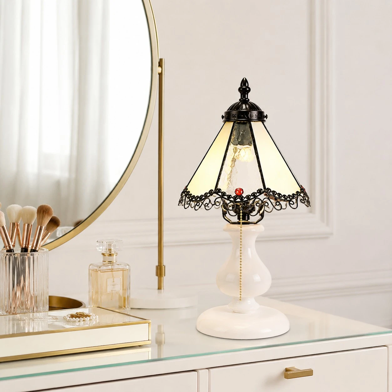 Pale yellow stained glass table lamp styled on a vanity beside a mirror