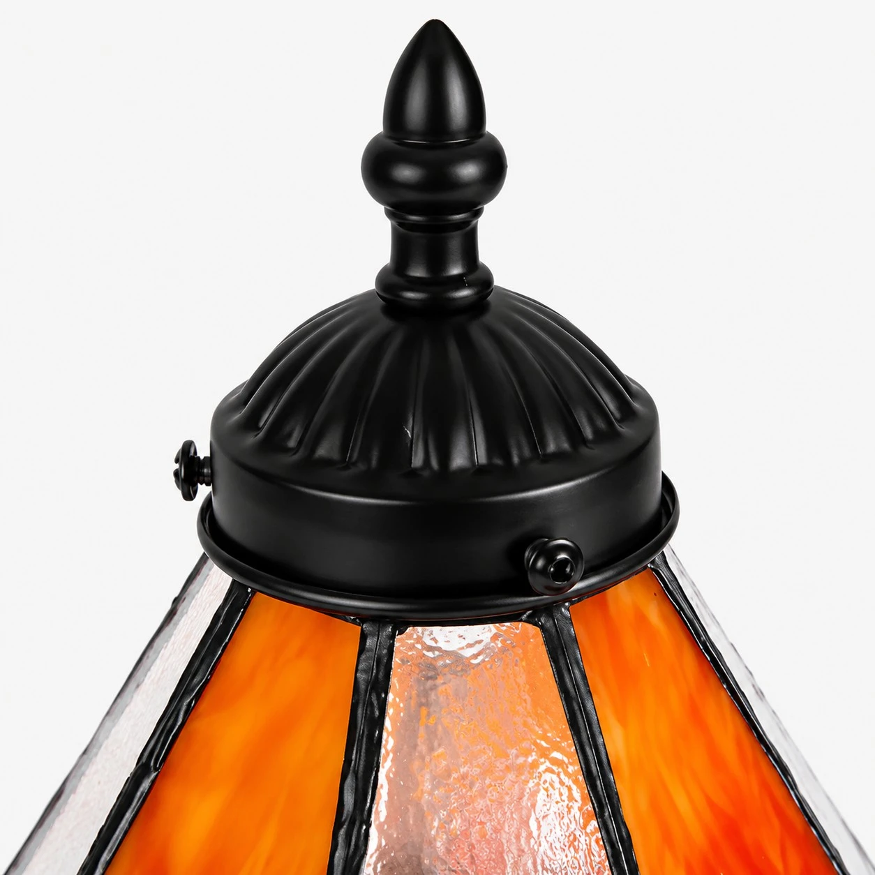 Close view of black metal finial and ribbed frame on the stained glass shade