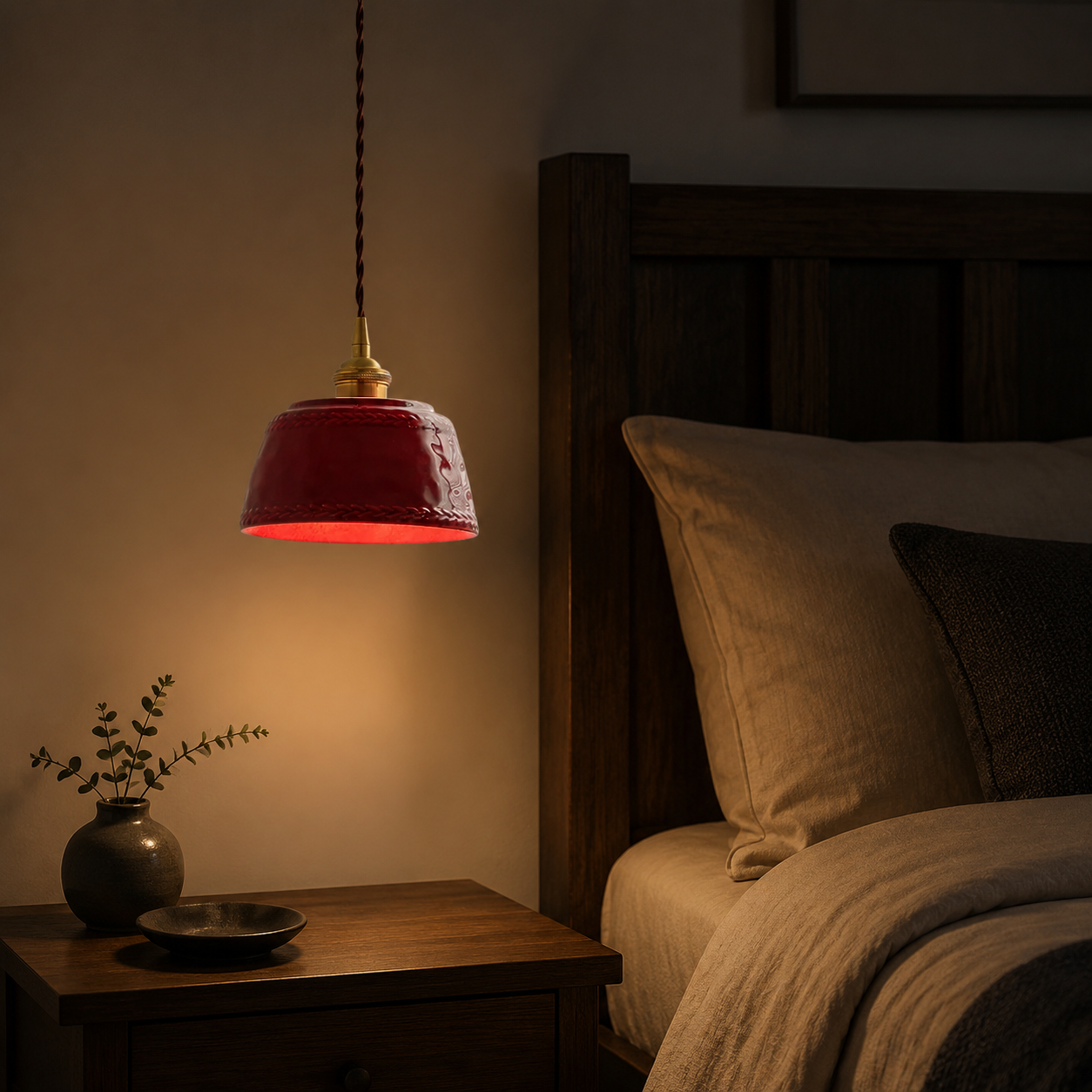 Rote Keramik-Pendelleuchte neben einem Bett