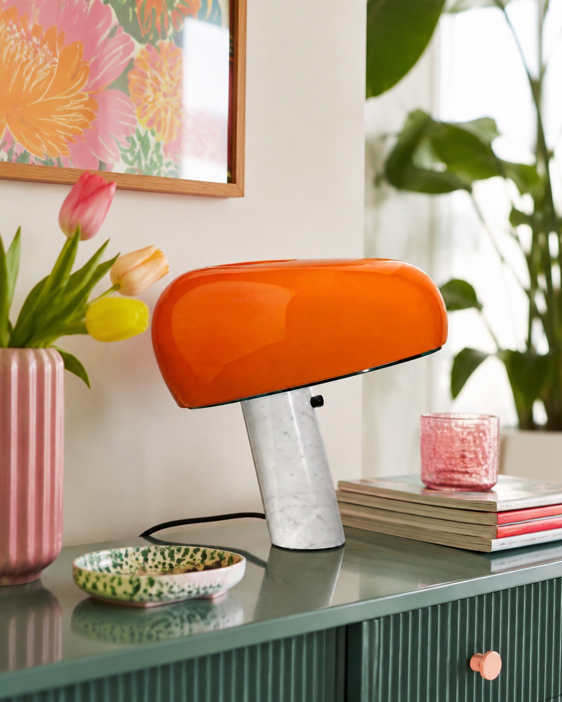 Lámpara de mesa Snoopy naranja sobre un aparador colorido