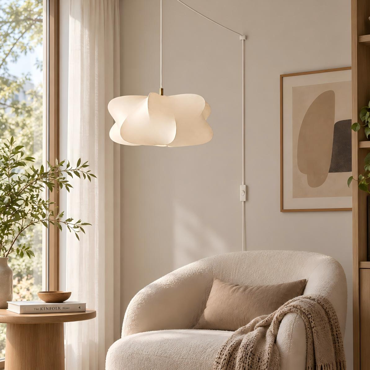 Lampada a sospensione bianca con presa europea accanto a una sedia da lettura vicino alla finestra