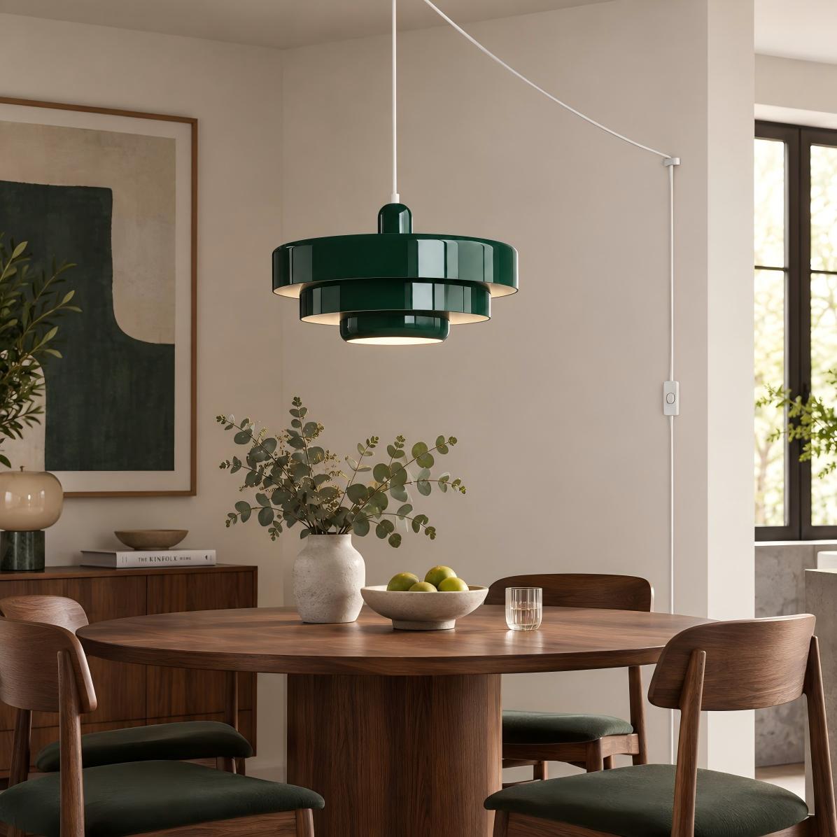 Donkergroene hanglamp boven een houten eettafel