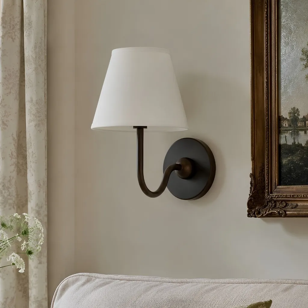 Geplooide stoffen wandlamp Luvora in geborsteld messing met een witte kap