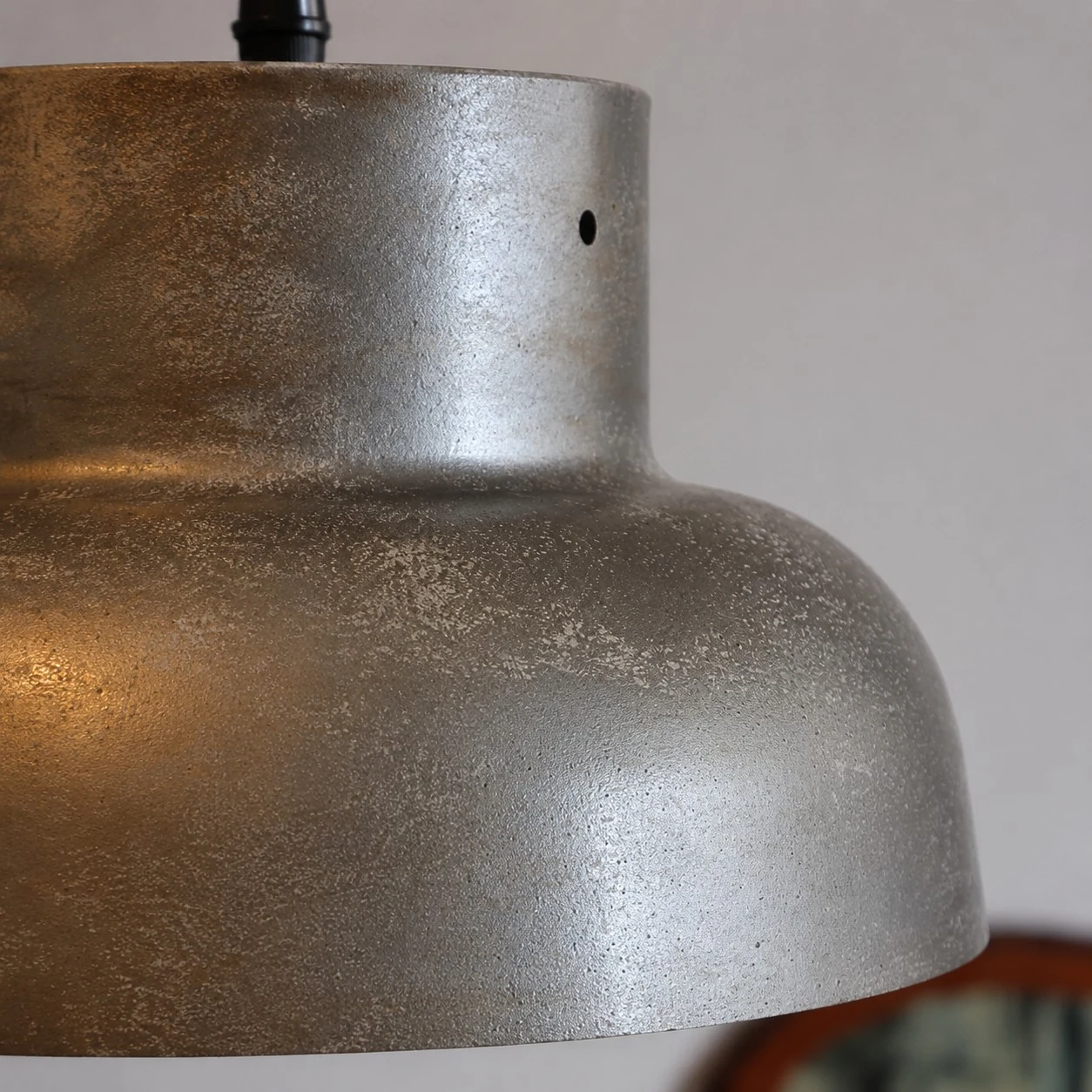 Nahaufnahme der Textur eines gealterten silbergrauen Metallschirms.